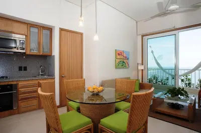 a kitchen and dining room with a glass table and chairs at Hotel Irotama del Mar in Santa Marta