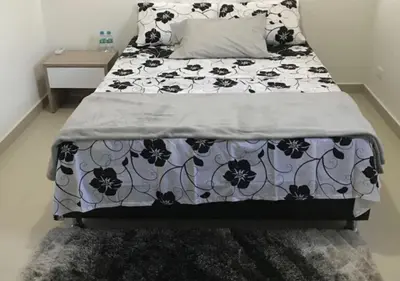 a bed with a black and white comforter on it at Apartamento Vacacional En La Zona Norte De Barranquilla in Barranquilla
