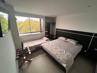 a bedroom with two beds and a window at Hotel La Esperanza in Cartagena de Indias