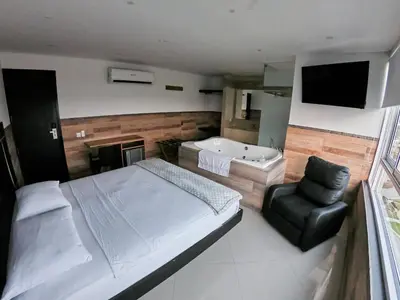 a bedroom with a bed and a tub and a chair at Hotel La Esperanza in Cartagena de Indias
