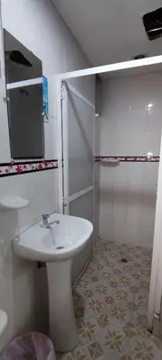 a white bathroom with a sink and a shower at Posada Dakema in Cartagena de Indias