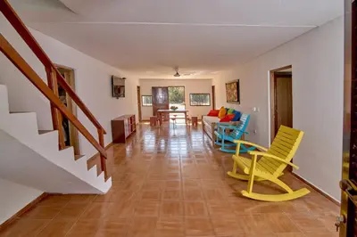 a living room with yellow chairs and a couch at Cabaña El Refugio in San Antero
