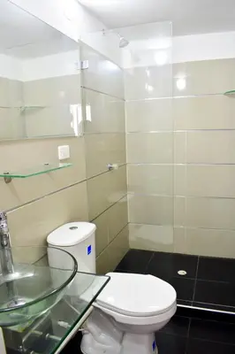 a bathroom with a toilet and a glass sink at Hotel Hernández CTG in Cartagena de Indias