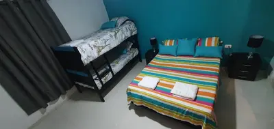 a small bedroom with a bed and a crib at Casa Evelyn in Cartagena de Indias