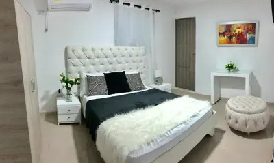 a white bedroom with a large white bed with a large white bed frame at Hotel Platinum Barranquilla in Barranquilla