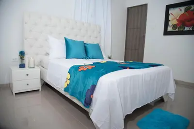 a bedroom with a large bed with blue pillows at Hotel Platinum Barranquilla in Barranquilla