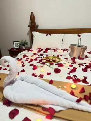 a bed with roses on it with glasses of wine at Hostal La Heroica in Cartagena de Indias