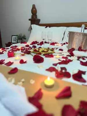 a table with red roses on a bed with wine glasses at Hostal La Heroica in Cartagena de Indias