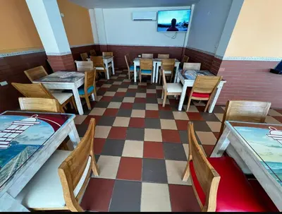 a restaurant with tables and chairs on a checkered floor at Hostal La Heroica in Cartagena de Indias