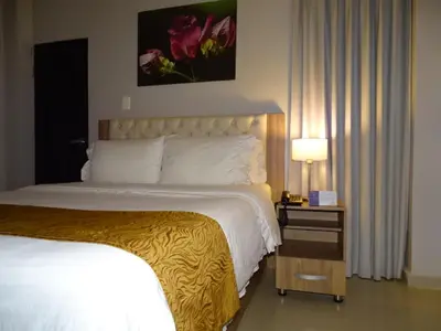 a hotel room with a bed and a table with a lamp at Hotel Prado Real in Barranquilla