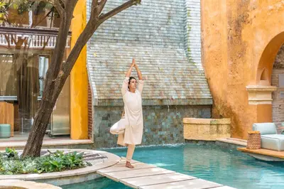 a woman doing yoga by a swimming pool at Casa Carolina Luxury Wellness Hotel in Cartagena de Indias