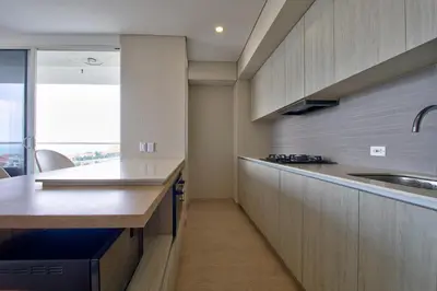 a kitchen with wooden cabinets and a counter top at Cielo Mar Regatta - LivinColombia in Cartagena de Indias