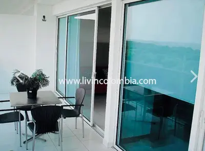 a dining room with a table and chairs and a glass window at Cartagena Boquilla Morros playa apt 1 in Cartagena de Indias