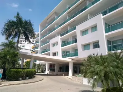 a large white building with palm trees in front of it at Cartagena Boquilla Morros playa apt 1 in Cartagena de Indias