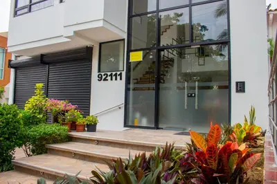 a building with glass doors and stairs in front at Hotel Boutique M in Barranquilla