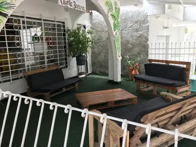 a patio with benches and tables in a building at La Quinta Bacana in Barranquilla