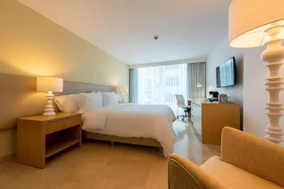 a hotel room with a large bed and a window at Radisson Cartagena Ocean Pavillion Hotel in Cartagena de Indias