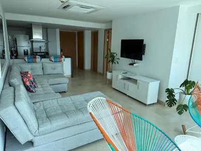 a living room with a couch and a flat screen tv at Bello apartamento dentro del Hotel Radisson Ocean Pavillion in Cartagena de Indias
