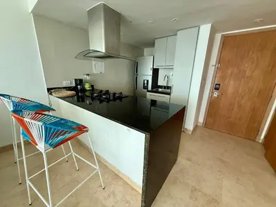 a kitchen with a counter and a chair in it at Bello apartamento dentro del Hotel Radisson Ocean Pavillion in Cartagena de Indias