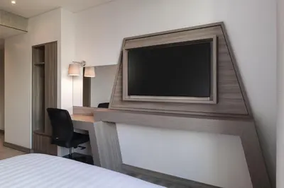 a hotel room with a flat screen tv on a wall at Hampton by Hilton Barranquilla in Barranquilla
