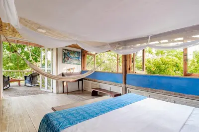 a bedroom with a bed and a hammock at Hotel Playa Manglares Isla Baru in Baru
