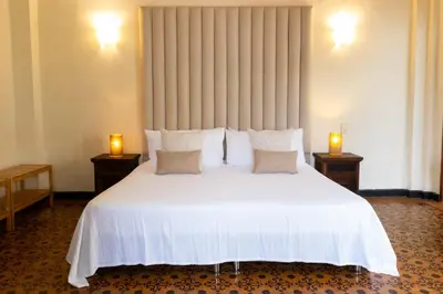 a bedroom with a large white bed with two lamps at Casa Bustamante Hotel Boutique in Cartagena de Indias