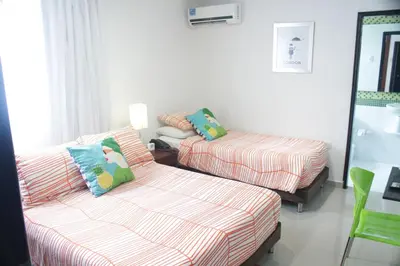 a living room with two beds and a couch at Hotel Golden House in Barranquilla