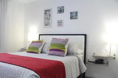 a bedroom with a bed with colorful pillows at Hotel Golden House in Barranquilla