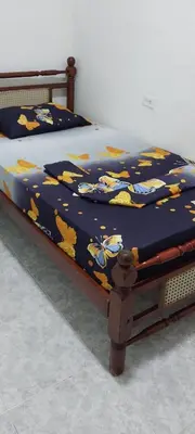 a bed with a blue blanket with flowers on it at LA MEDELLIN HOSTAL in Cartagena de Indias