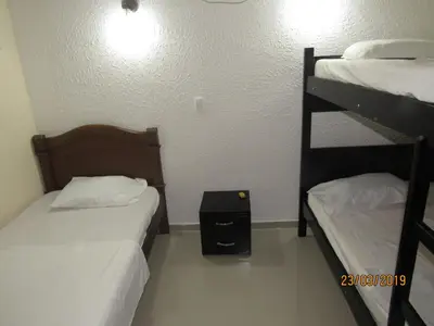 a bedroom with two bunk beds and a night stand at Hotel Del Mar Inn in Barranquilla