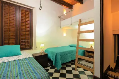 a bedroom with two beds and a bunk bed at Casa San Pedro - Exclusive 3BR Colonial Apt in Centro Historico by Huespedia in Cartagena de Indias