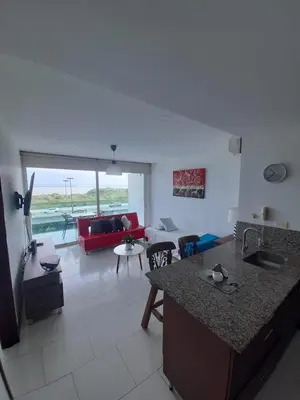 a kitchen and living room with a red couch at Cartagena Morros playa edificio frente al mar 1 in Cartagena de Indias