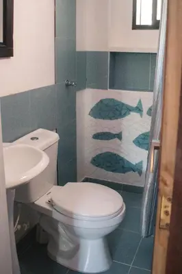 a bathroom with a white toilet and a sink at Casa Caracola in Tubará