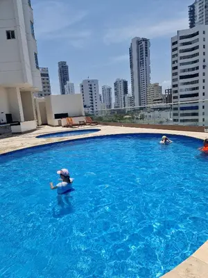 a person in a swimming pool on top of a building at Encantador apartamento frente a la playa in Cartagena de Indias