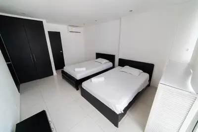 a small bedroom with two beds and a chair at Cozy Apartment in El Laguito in Cartagena de Indias