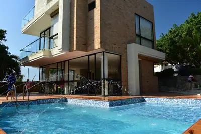 a house with a swimming pool in front of a building at Casa en Santa Veronica Atlantico in Santa Veronica