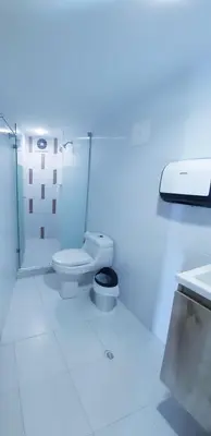a white bathroom with a toilet and a sink at Ocean blue Ed Conquistador in Cartagena de Indias