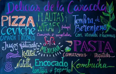 a chalkboard with the names of different languages at Canto de Caracola in Rincón