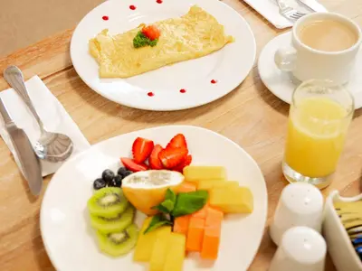 a table with two plates of breakfast food and a cup of juice at Grand Sirenis Cartagena in Cartagena de Indias