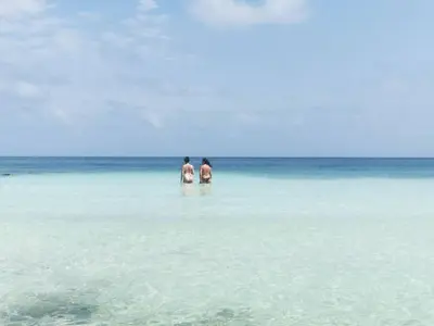two people standing in the water in the ocean at Casa Tinti in Tintipan Island