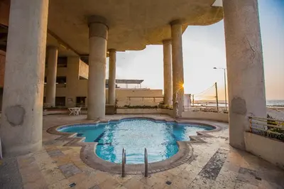 a swimming pool in a building next to the beach at Apt frente al Mar 10 min a pie Centro Histórico in Cartagena de Indias
