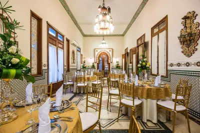 a dining room with tables and chairs and a chandelier at Hotel Majestic in Barranquilla