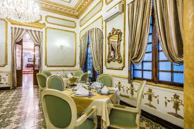a dining room with tables and chairs and a chandelier at Hotel Majestic in Barranquilla
