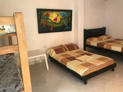 a bedroom with two beds and a painting on the wall at Cabaña La Fortaleza in Tolú