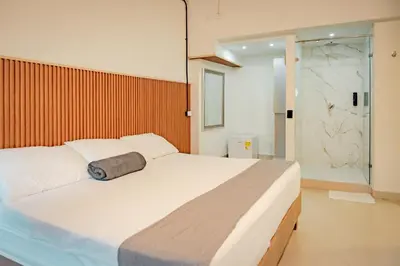 a bedroom with a large white bed and a shower at Casa Amanzi Cartagena by Bernalo Hotels in Cartagena de Indias
