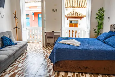 a living room with a bed and a couch at Hostal Badillo SV in Cartagena de Indias