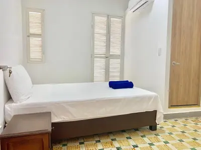 a bedroom with a bed with a blue towel on it at Casa de la Cruz Centro Historico in Cartagena de Indias
