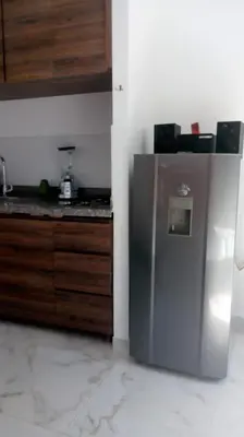 a kitchen with a stainless steel refrigerator and wooden cabinets at VILLA MORELI in Papare