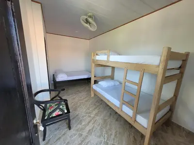 a room with two bunk beds and a chair at Alojamiento Bityn in Paso Nuevo