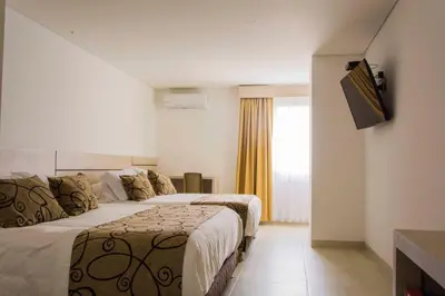 a hotel room with two beds and a television at Hotel Arawak Plaza in Sincelejo